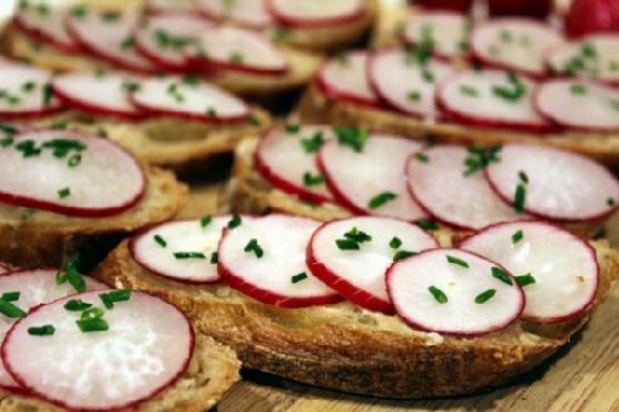 Sliced baguette with anchovy chive butter and radishes